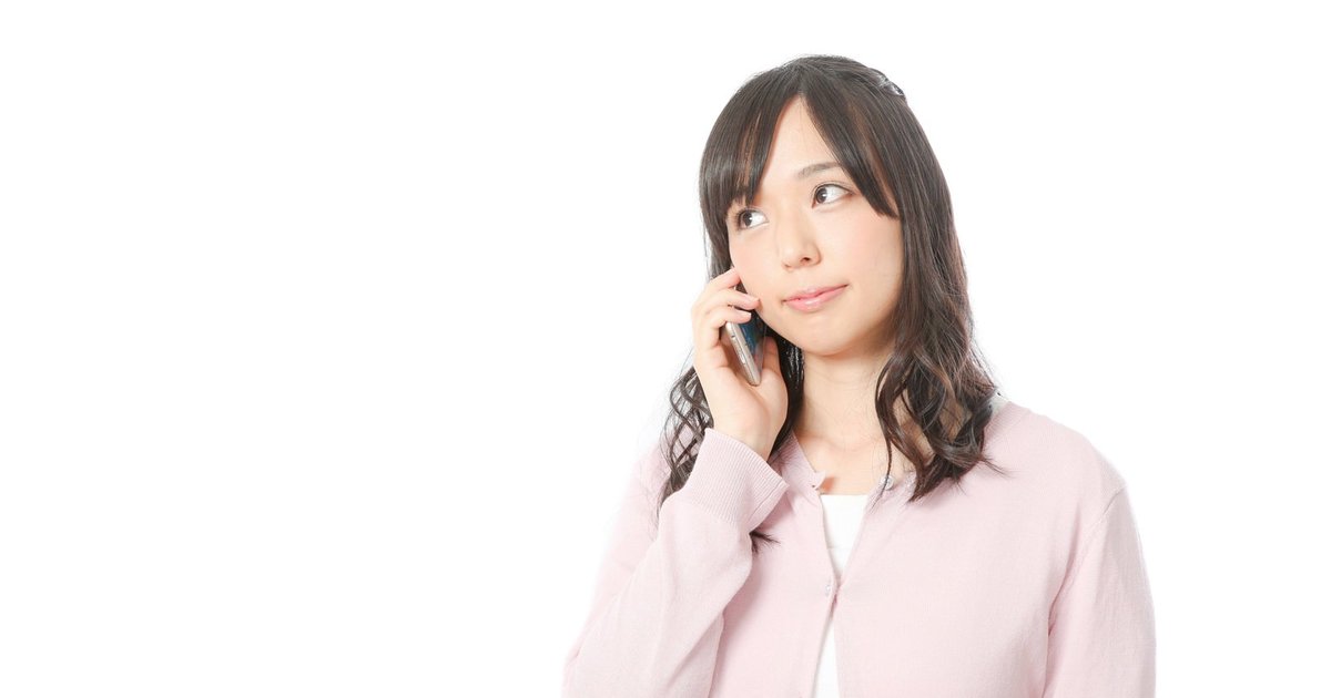電話で話しながら微笑む女性